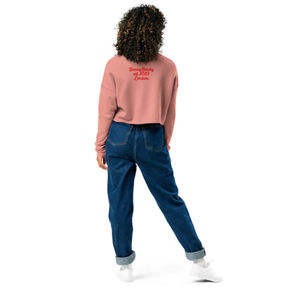 A model wearing The Sisterhood Crop Sweatshirt, showing the raw hem, dropped shoulder cut, and the embroidered "Female Culture" motto on the chest and heritage signature printed at the back