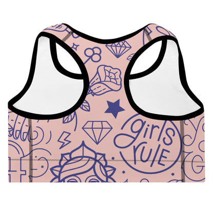 A close up of The Sisterhood Performance Bra, showing the supportive fit and the high-impact "Girl Power" collage print.