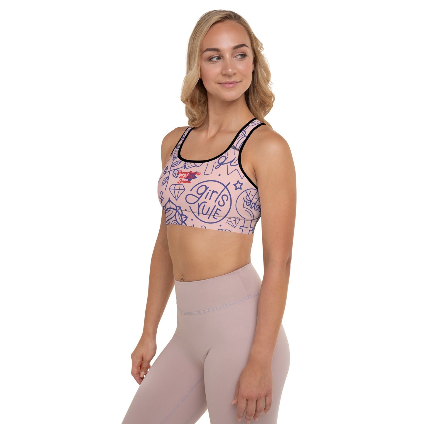 A model wearing The Sisterhood Performance Bra, showing the supportive fit and the high-impact "Girl Power" collage print.