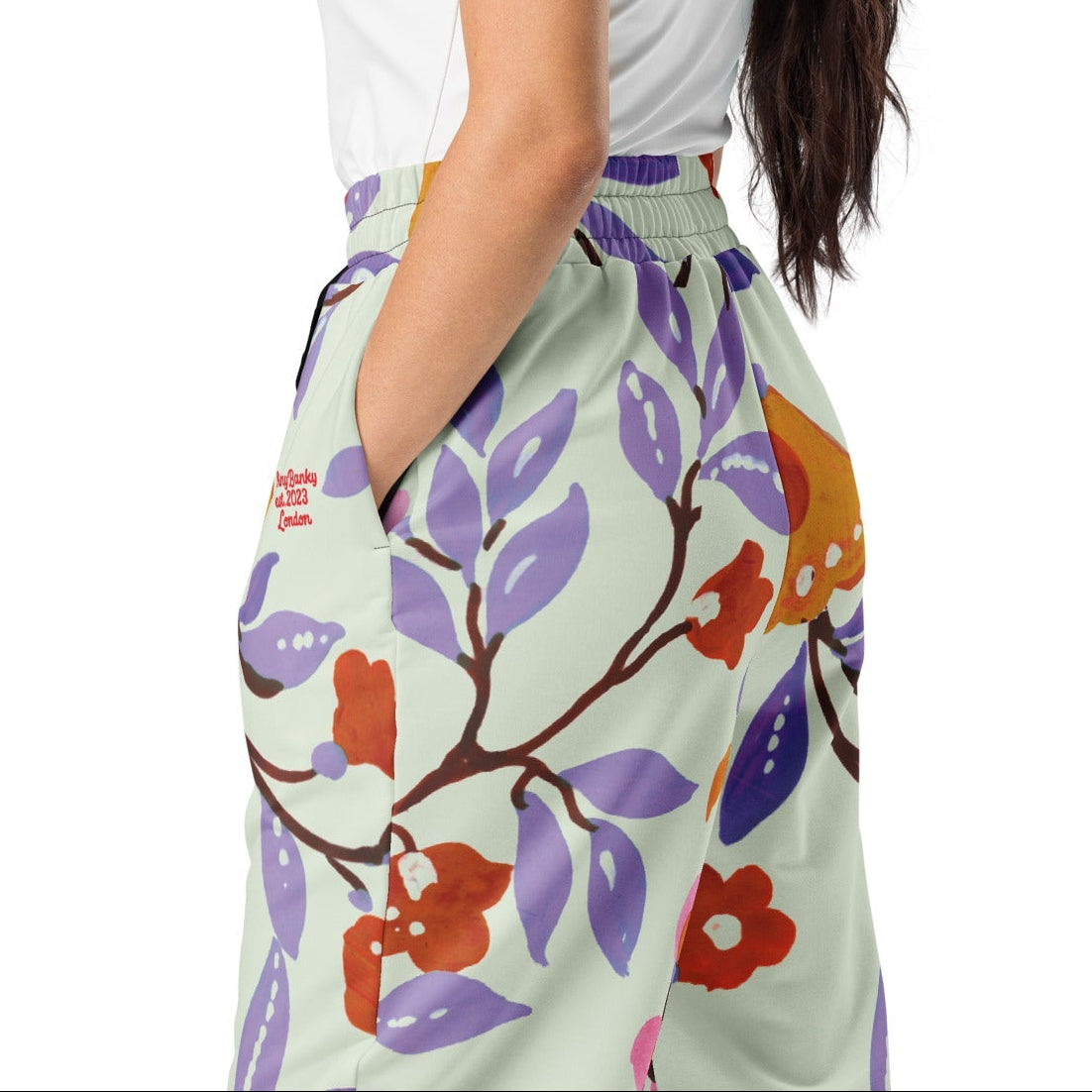 A close-up of The Sloane Square Flow Wide Joggers, highlighting the soft texture and the elegant pastel pink and lilac oversized floral print.