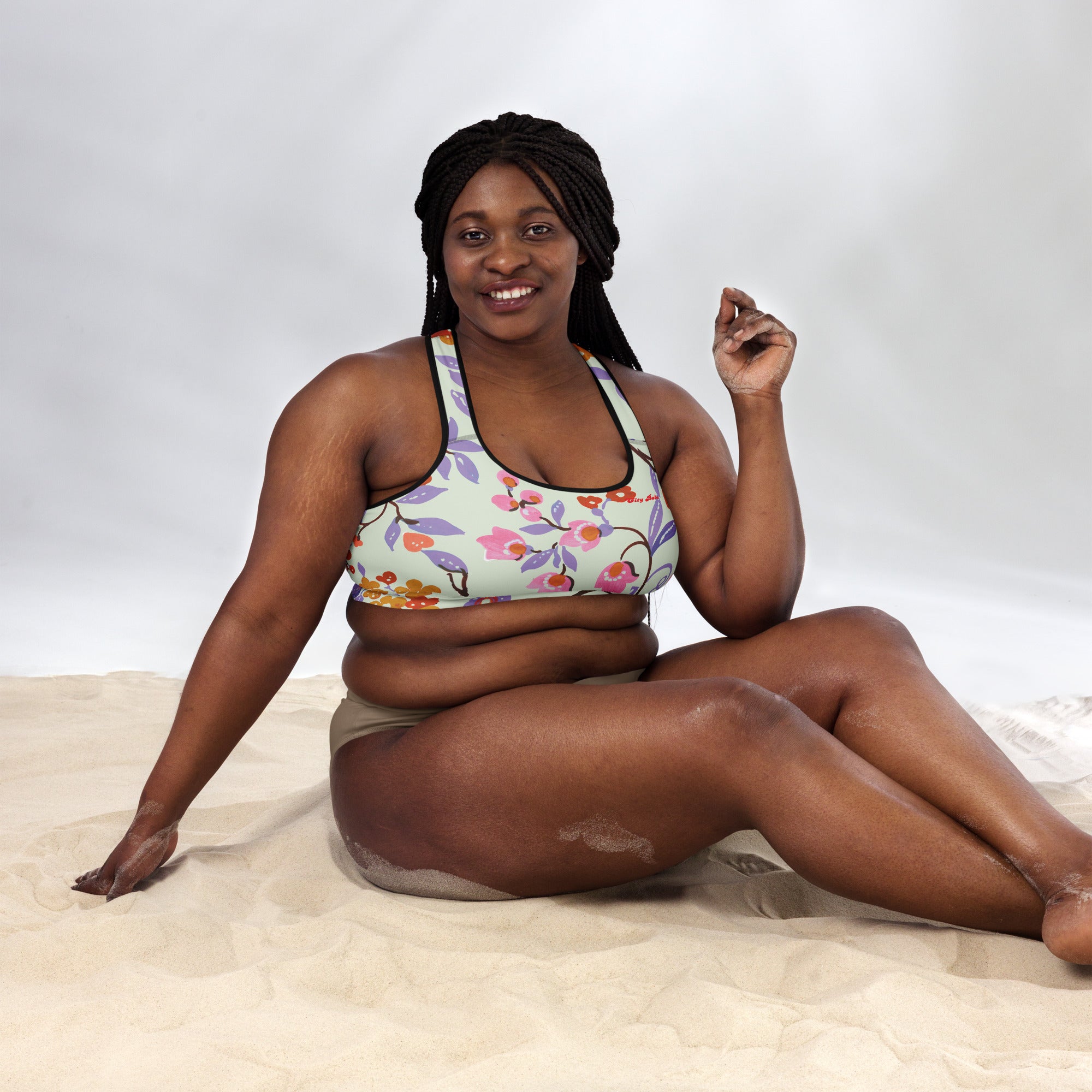 A model wearing The Sloane Square Performance Bra, showing the supportive fit and the elegant pink and lilac oversized floral print.