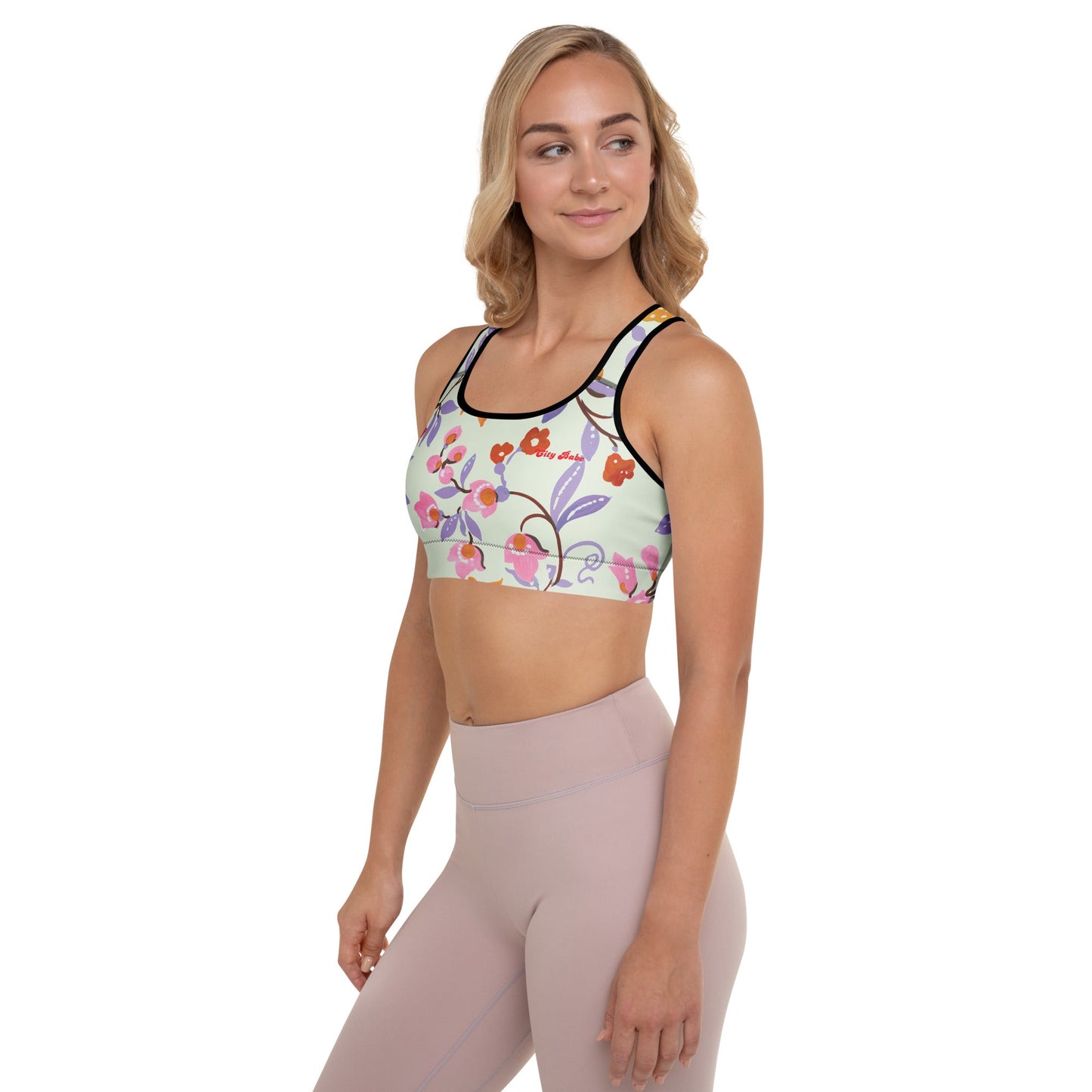 A model wearing The Sloane Square Performance Bra, showing the supportive fit and the elegant pink and lilac oversized floral print.