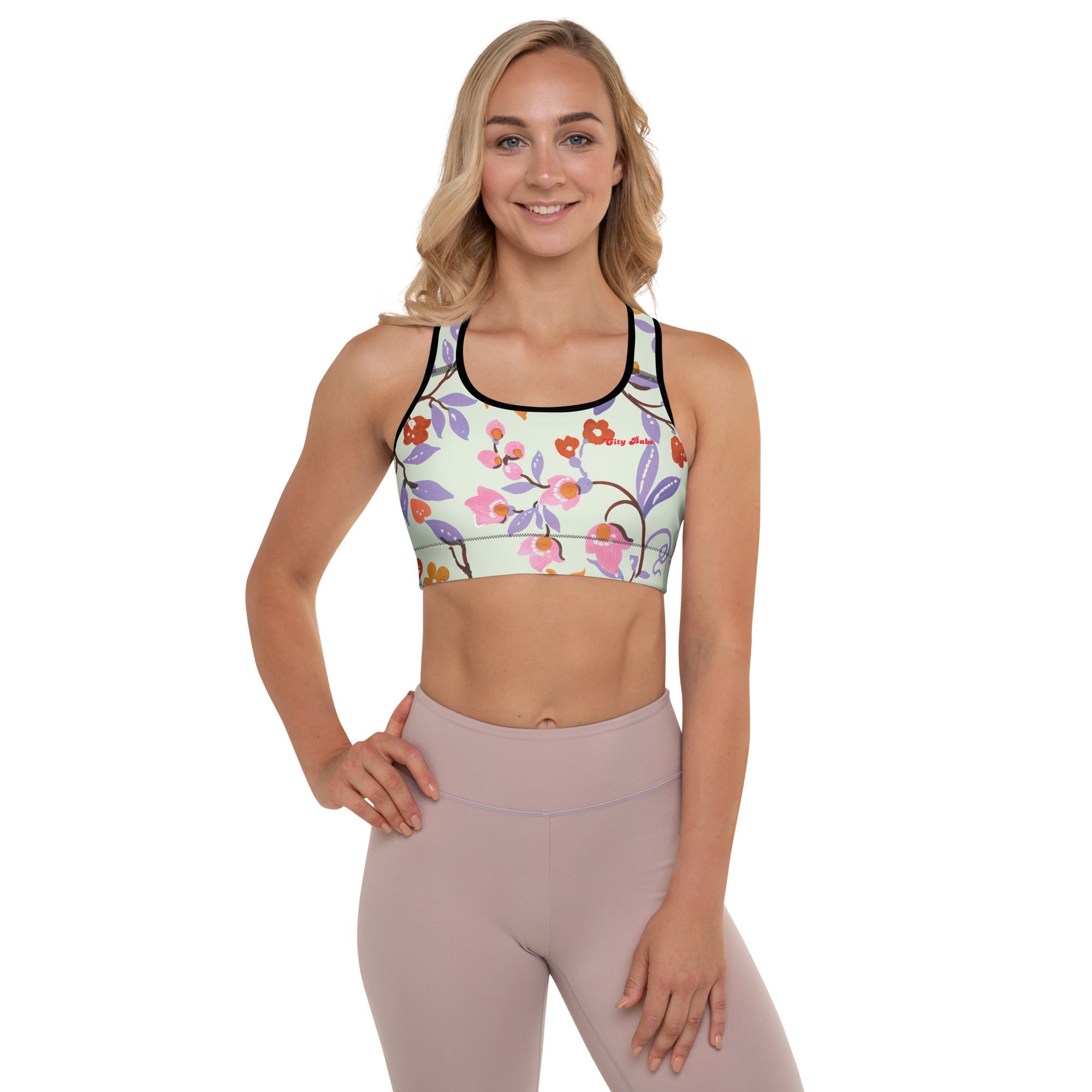 A model wearing The Sloane Square Performance Bra, showing the supportive fit and the elegant pink and lilac oversized floral print.