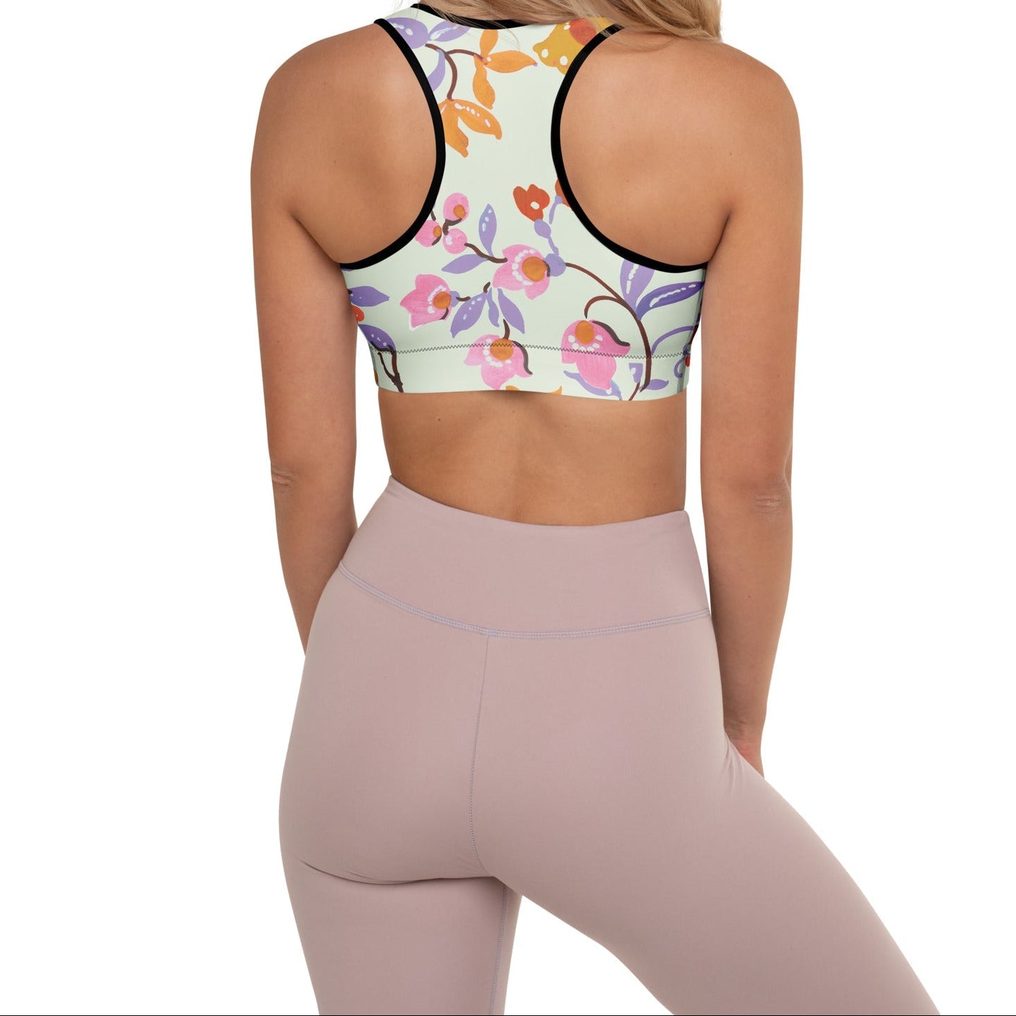 A model wearing The Sloane Square Performance Bra, showing the supportive fit and the elegant pink and lilac oversized floral print.