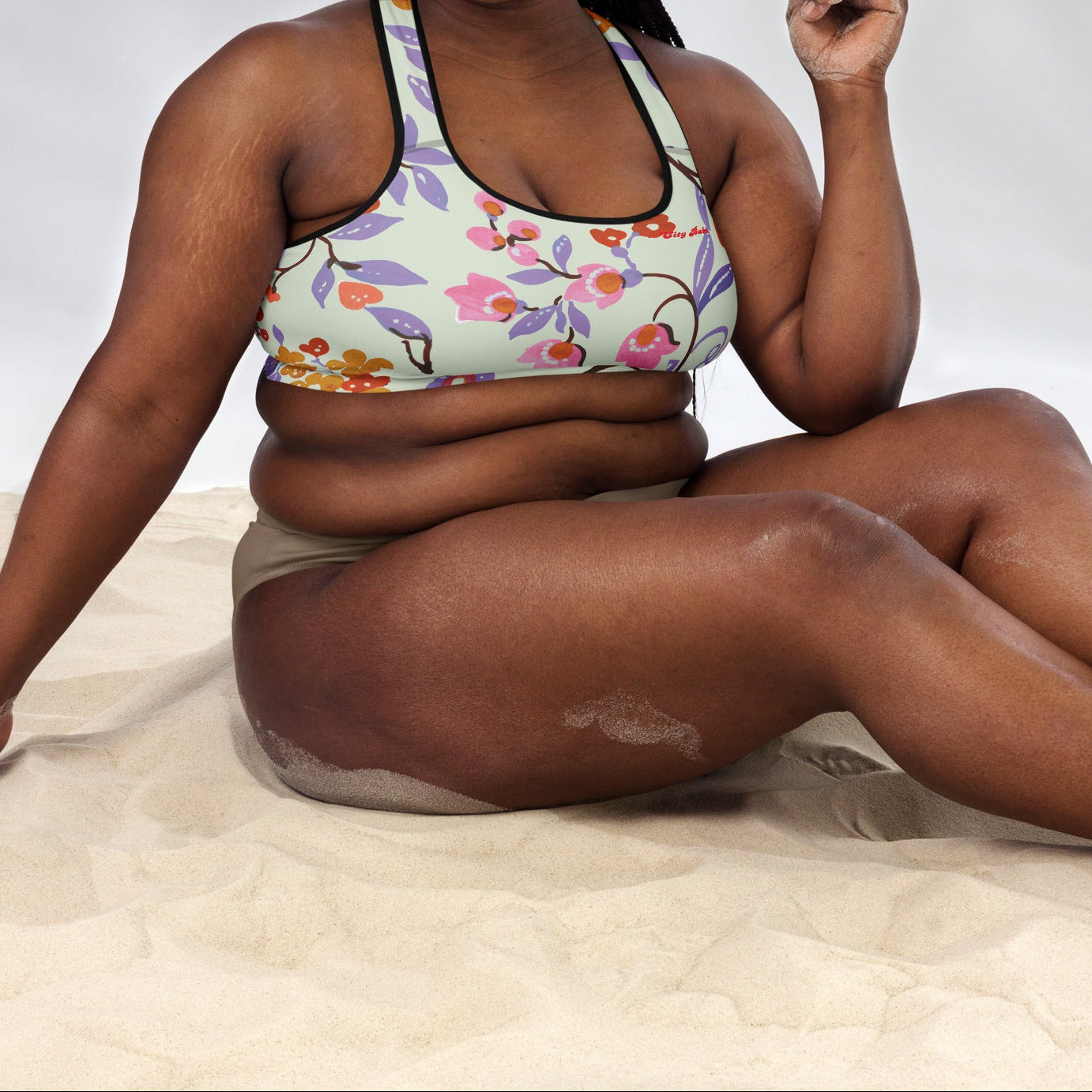 A model wearing The Sloane Square Performance Bra, showing the supportive fit and the elegant pink and lilac oversized floral print.