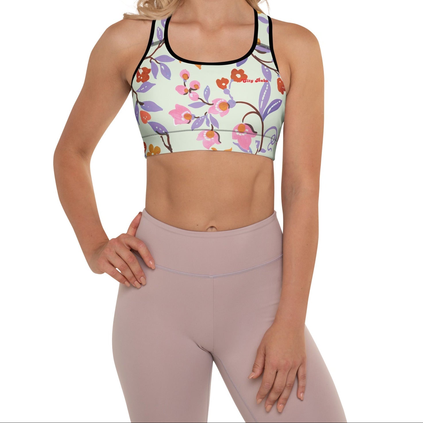 A model wearing The Sloane Square Performance Bra, showing the supportive fit and the elegant pink and lilac oversized floral print.