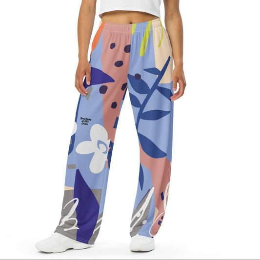 Model wearing the Surrey Flow Joggers featuring a vibrant floral print and lilac and blue hues highlighting the wide leg cut and relaxed fit with side pockets and adjustable waist.