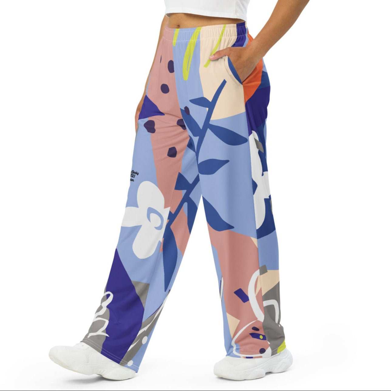Model wearing the Surrey Flow Joggers featuring a vibrant floral print and lilac and blue hues highlighting the wide leg cut and relaxed fit with side pockets and adjustable waist.