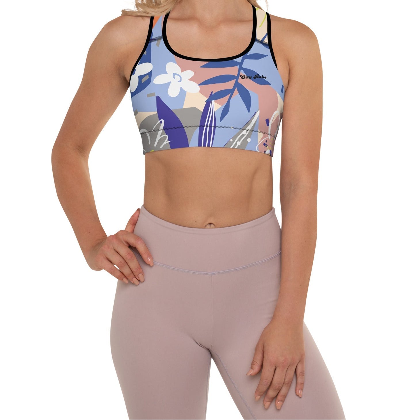 A model wearing the surrey performance bra with the print city babe on a floral print with lilac and beige hues