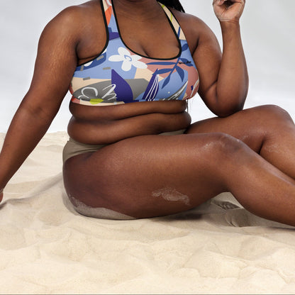 A model wearing the surrey performance bra with the print city babe on a floral print with lilac and beige hues