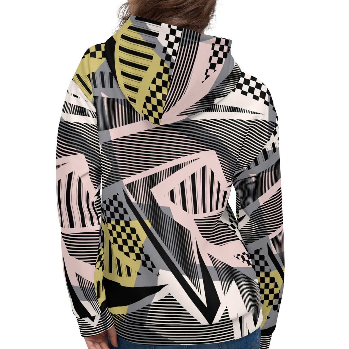 A model wearing the Sydney Hoodie. The image highlights the Art Deco-inspired pattern of checkers and pinstripes in soft pink, sand, and olive tones, featuring red London branding.