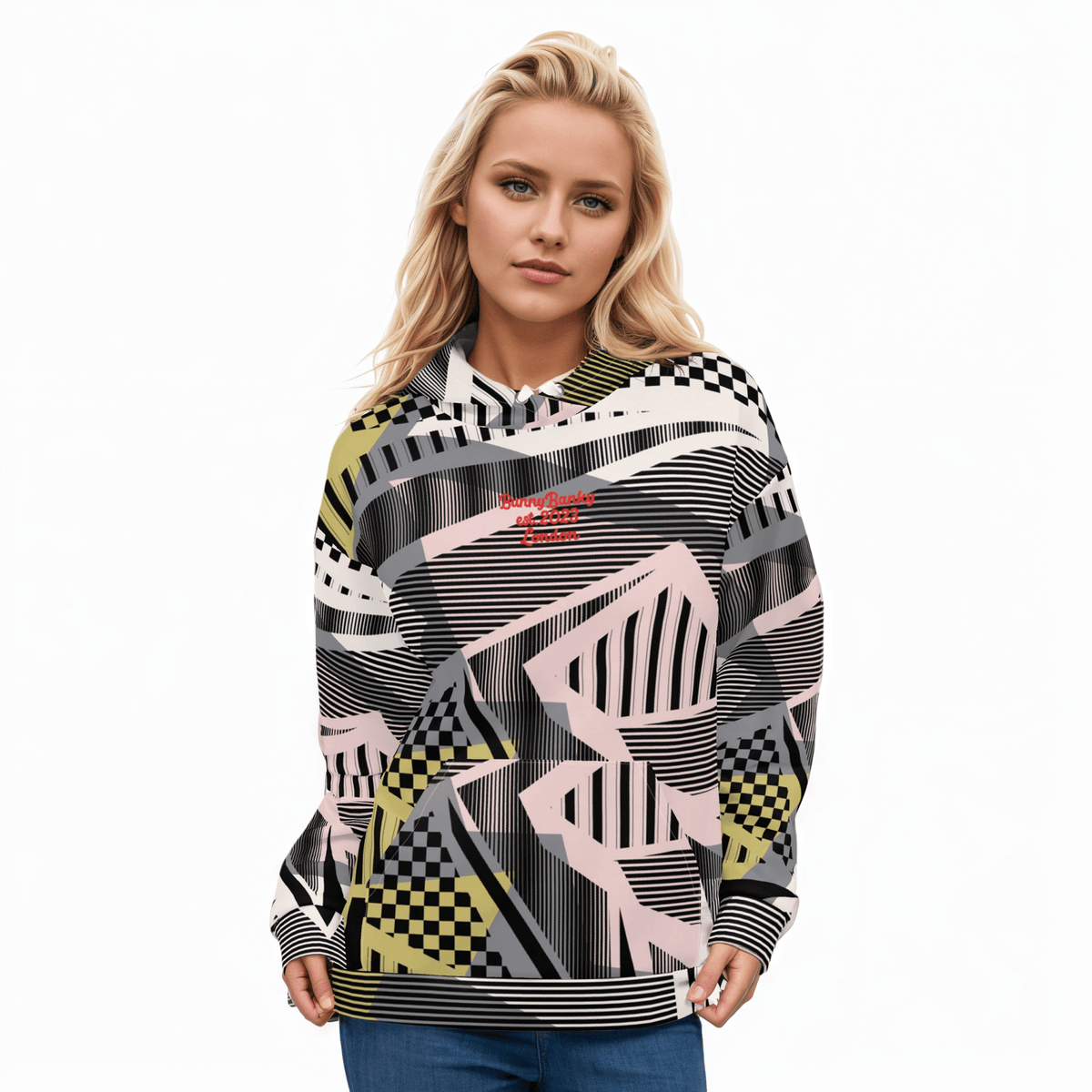 A BunnyBankY AI proprietary model wearing the Sydney Hoodie. The image highlights the Art Deco-inspired pattern of checkers and pinstripes in soft pink, sand, and olive tones, featuring red London branding.