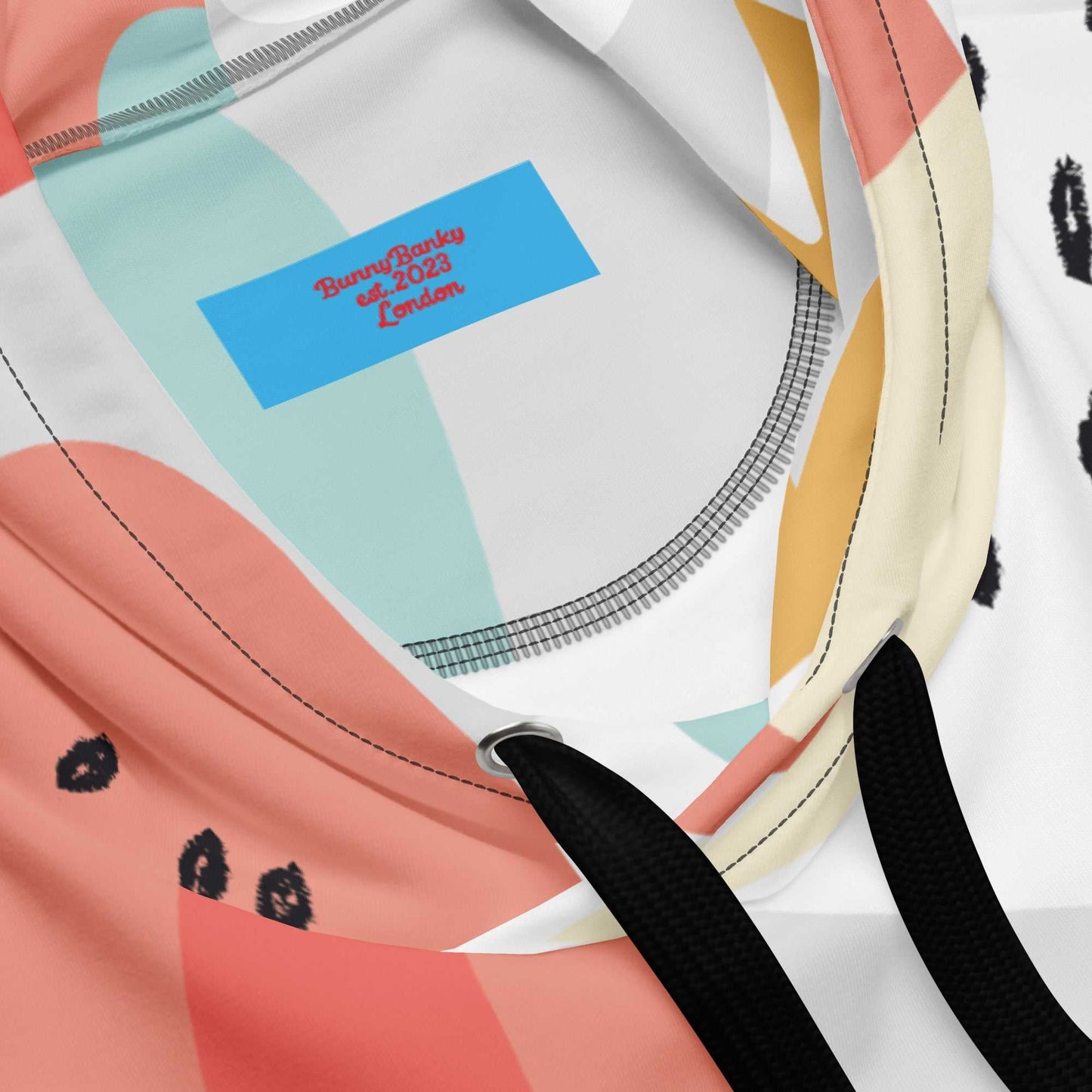 Close-up of the Terra Resort Hoodie. The image focuses on the intricate earth-tone patterns and the soft, high-quality finish of the recycled brushed fleece fabric, and the signature branding on the inside label.