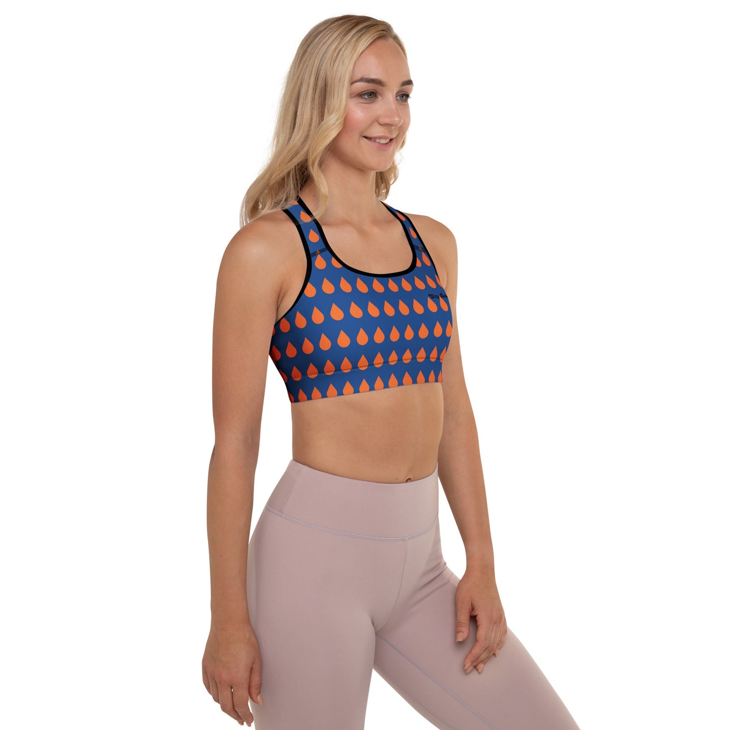 A model wearing The Thames Performance Bra, showing the supportive fit and the sophisticated orange drops print on the deep navy blue background. Highlights the garment's construction and the City Babe text printed in black on the top left 