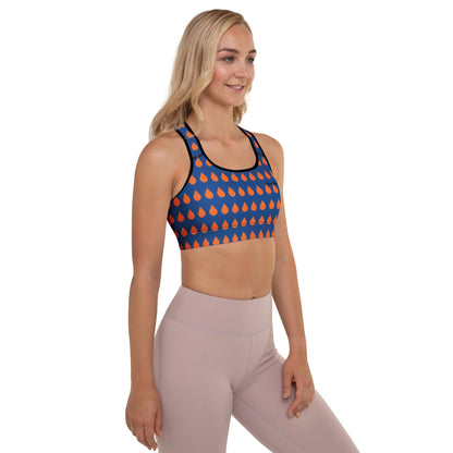 A model wearing The Thames Performance Bra, showing the supportive fit and the sophisticated orange drops print on the deep navy blue background. Highlights the garment's construction and the City Babe text printed in black on the top left 