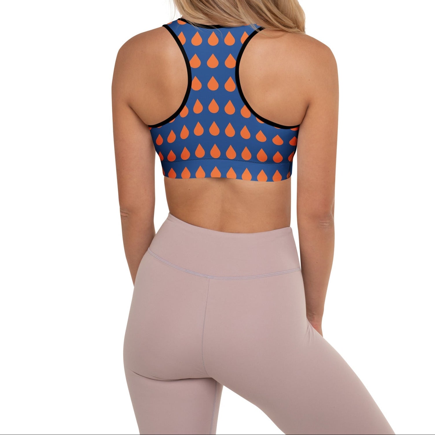 A model wearing The Thames Performance Bra, showing the supportive fit and the sophisticated orange drops print on the deep navy blue background. Highlights the garment's construction and the City Babe text printed in black on the top left 