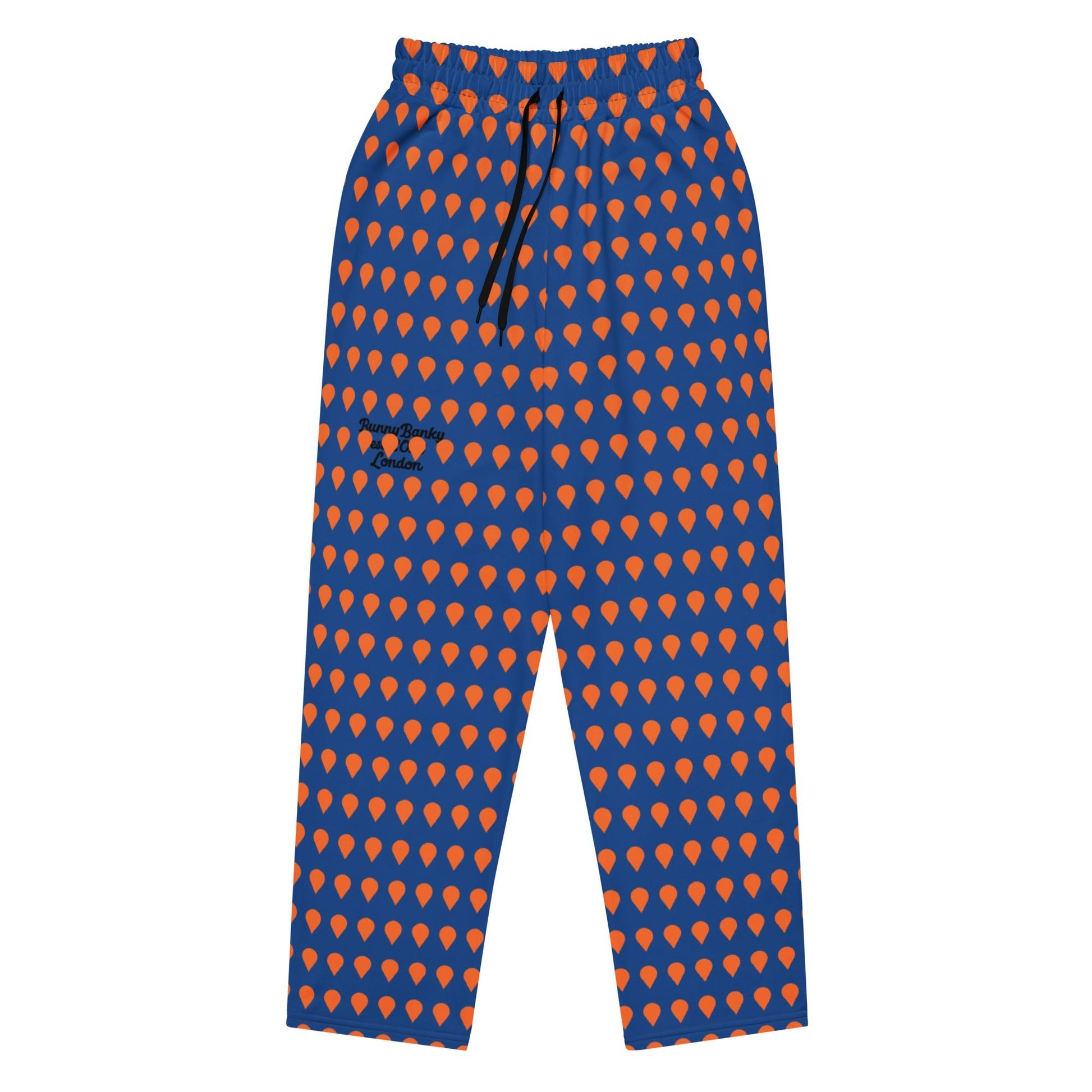 A close up of The Thames Flow Joggers, showing the wide-leg, relaxed silhouette and the orange drop print on the deep navy blue background, and the heritage signature in black