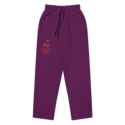 A close-up of The Tokyo Purple Flow Joggers, highlighting the playful Pop Cherry print and the heritage signature logo embroidered on the dark purple recycled polyester.