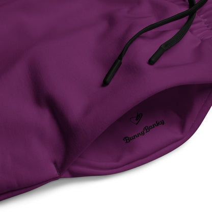 A close-up of The Tokyo Purple Flow  Joggers, highlighting the heritage signature logo printed on the dark purple recycled polyester.