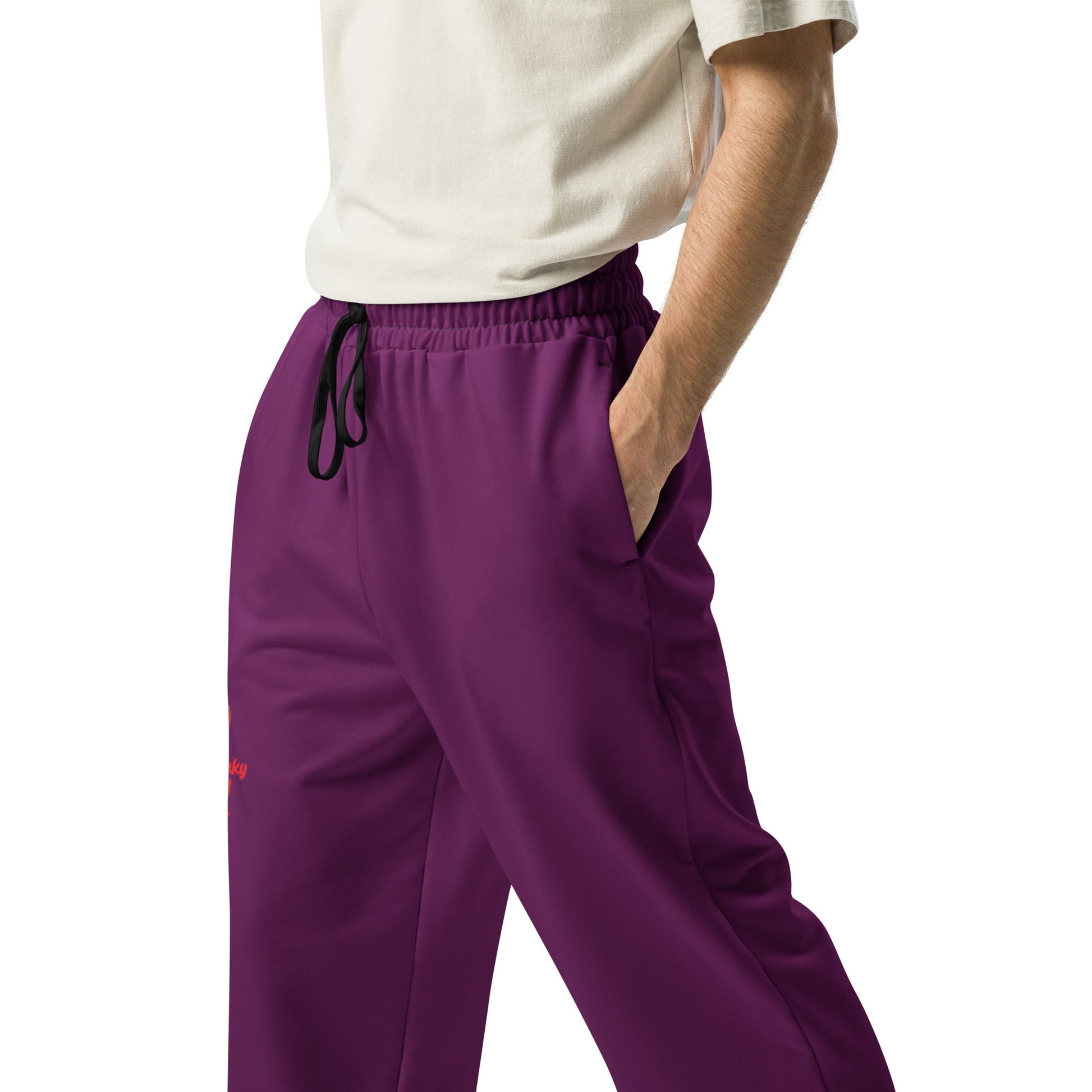 A model wearing The Tokyo Purple Flow Wide Joggers, showing the relaxed, wide-leg cut and the playful Pop Cherry print on the dark purple fabric.