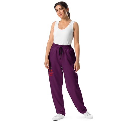 A model wearing The Tokyo Purple Flow Wide Joggers, showing the relaxed, wide-leg cut and the playful Pop Cherry print on the dark purple fabric.