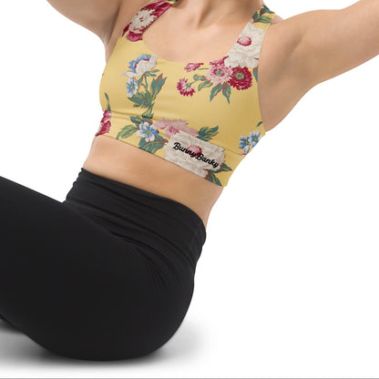 Model wearing the Toronto Longline Performance Bra featuring a pattern of large vintage florals in yellow background.