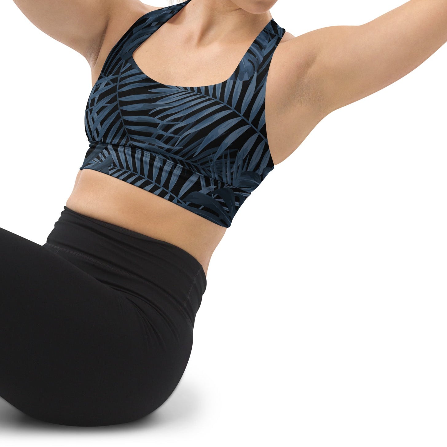 A model wearing The Toulouse Longline Performance Bra, showing the supportive fit, the extended longline silhouette, and the elegant dark botanical print on the navy background.