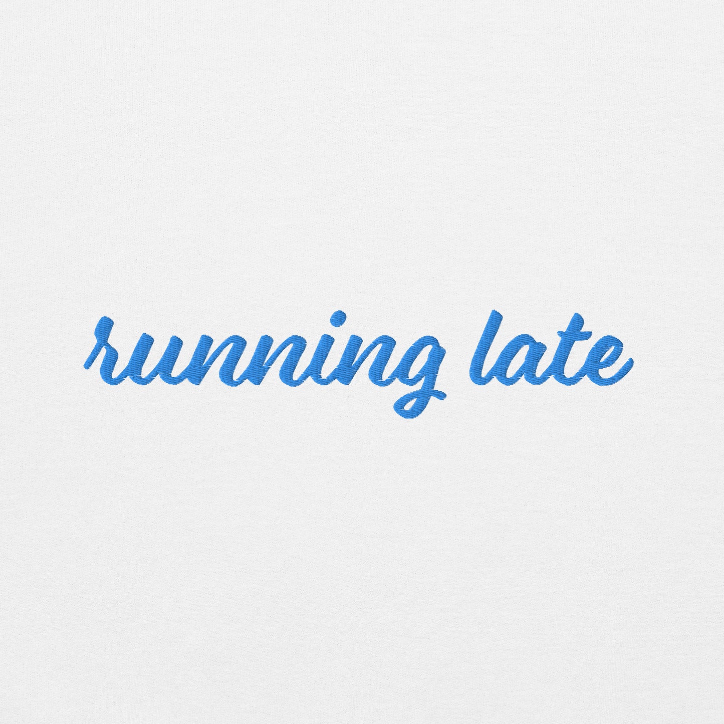 A close-up of The Running Late Sweatshirt, highlighting the "Running Late" embroidery and the iconic heart logo on the sleev
