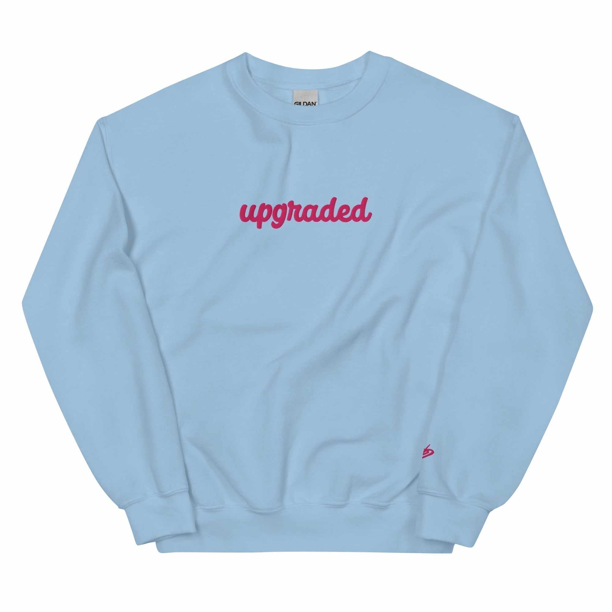 A close-up of The Upgraded Sweatshirt, highlighting the bold Upgraded text embroidered in fuschia on the chest, the soft air-jet spun fabric, and the detailed heritage logo print on the back.