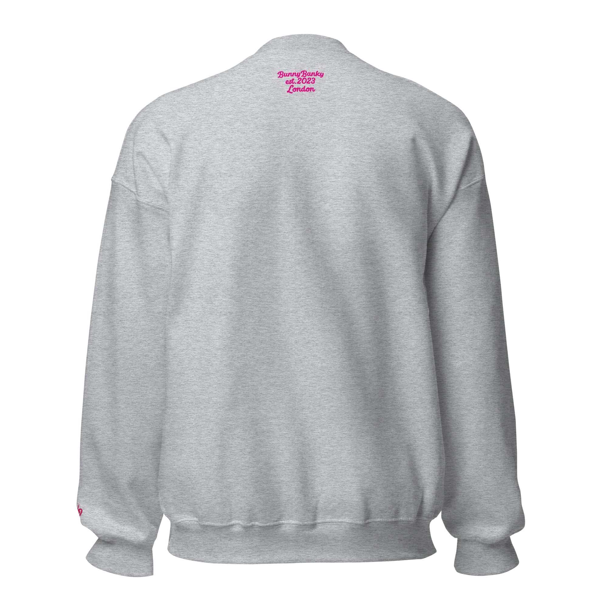 A close-up of The Upgraded Sweatshirt, highlighting the bold Upgraded text embroidered in fuschia on the chest, the soft air-jet spun fabric, and the detailed heritage logo print on the back.