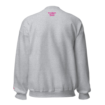 A close-up of The Upgrade Sweatshirt, highlighting the bold "Upgraded" text embroidered in fuschia on the chest, the soft air-jet spun fabric, and the detailed heritage logo print on the back.