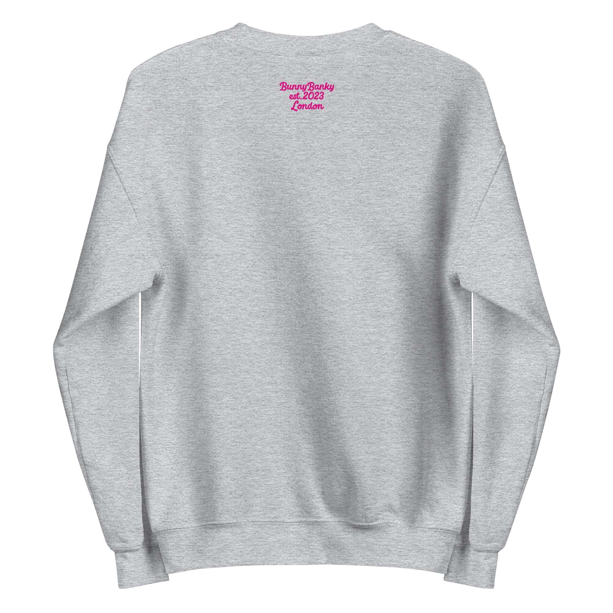 A close-up of The Upgraded Sweatshirt, highlighting the bold Upgraded text embroidered in fuschia on the chest, the soft air-jet spun fabric, and the detailed heritage logo print on the back.