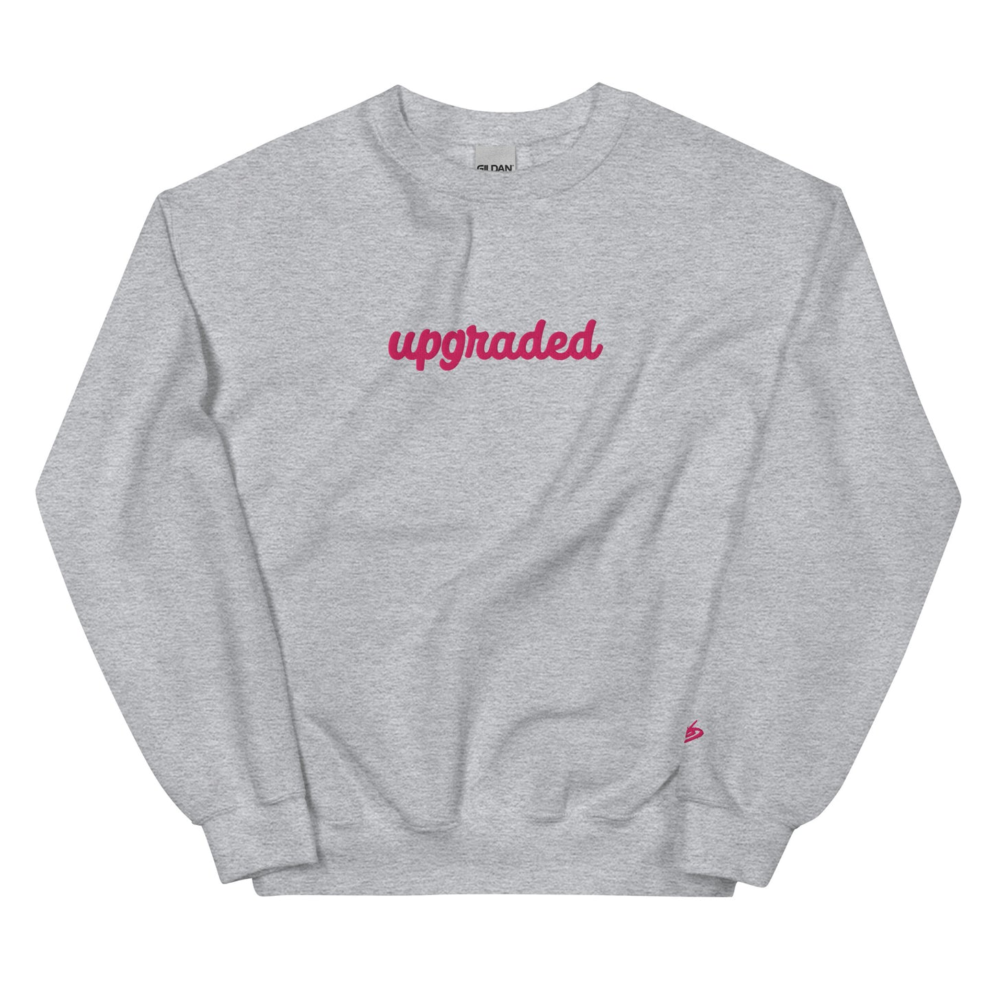 A close-up of The Upgrade Sweatshirt, highlighting the bold "Upgraded" text embroidered in fuschia on the chest, the soft air-jet spun fabric, and the detailed heritage logo print on the back.