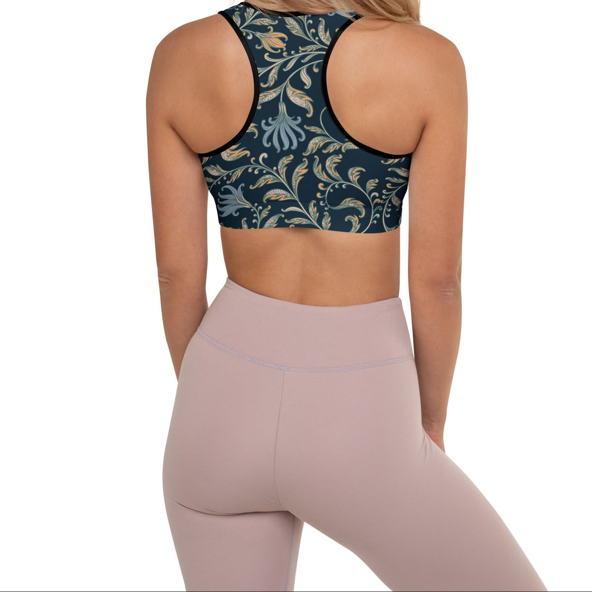 Woman wearing the venice performance bra, a baroque patterned sports bra and leggings on a white background