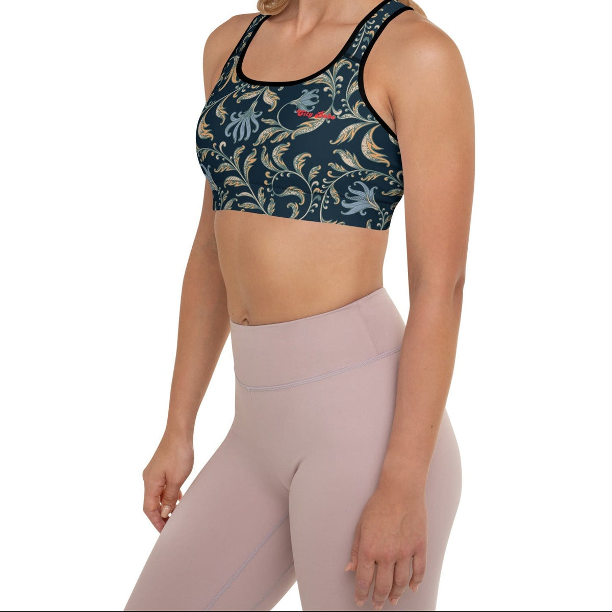 Model wearing the Venice Performance Bra featuring a parsley and floral pattern in dark blue with beige and light blue details, and the text City Babe at the top left.