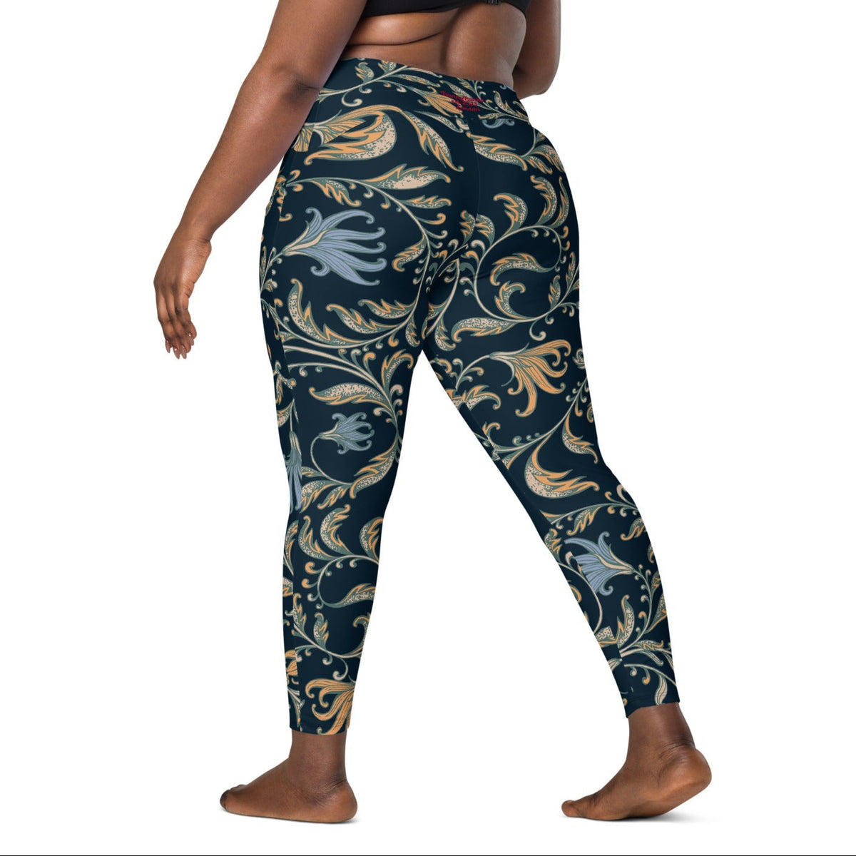 model wearing the Venice  high-waisted sculpt leggings featuring an intricate gold and slate-blue floral filigree print over a dark blue base