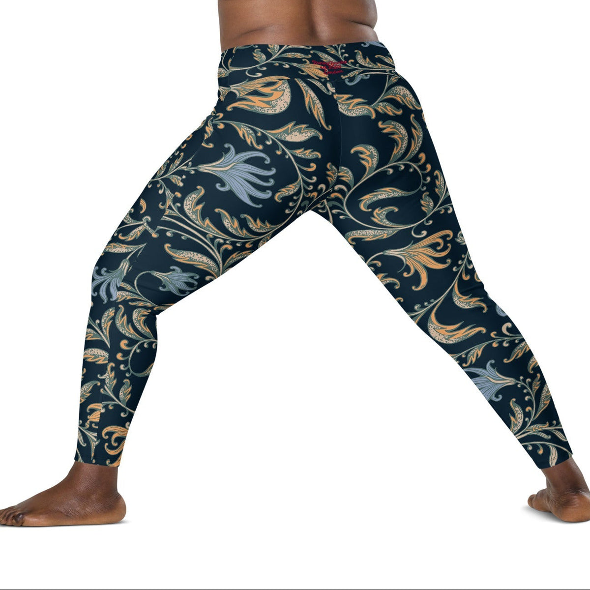 model wearing the Venice  high-waisted sculpt leggings featuring an intricate gold and slate-blue floral filigree print over a dark blue base