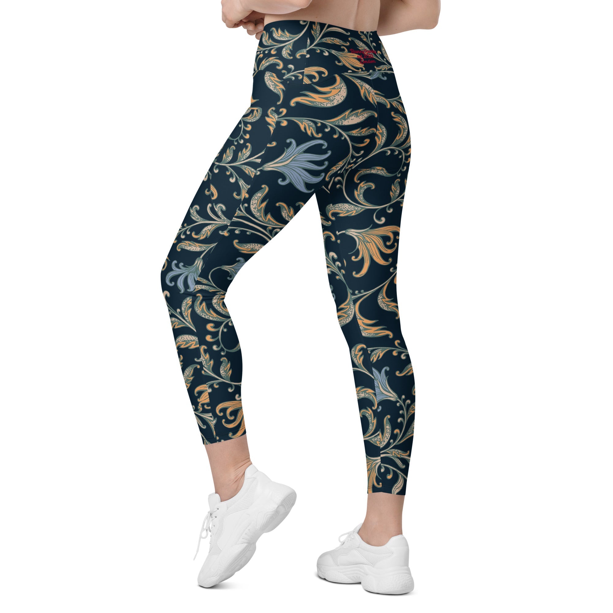 model wearing the Venice  high-waisted sculpt leggings featuring an intricate gold and slate-blue floral filigree print over a dark blue base