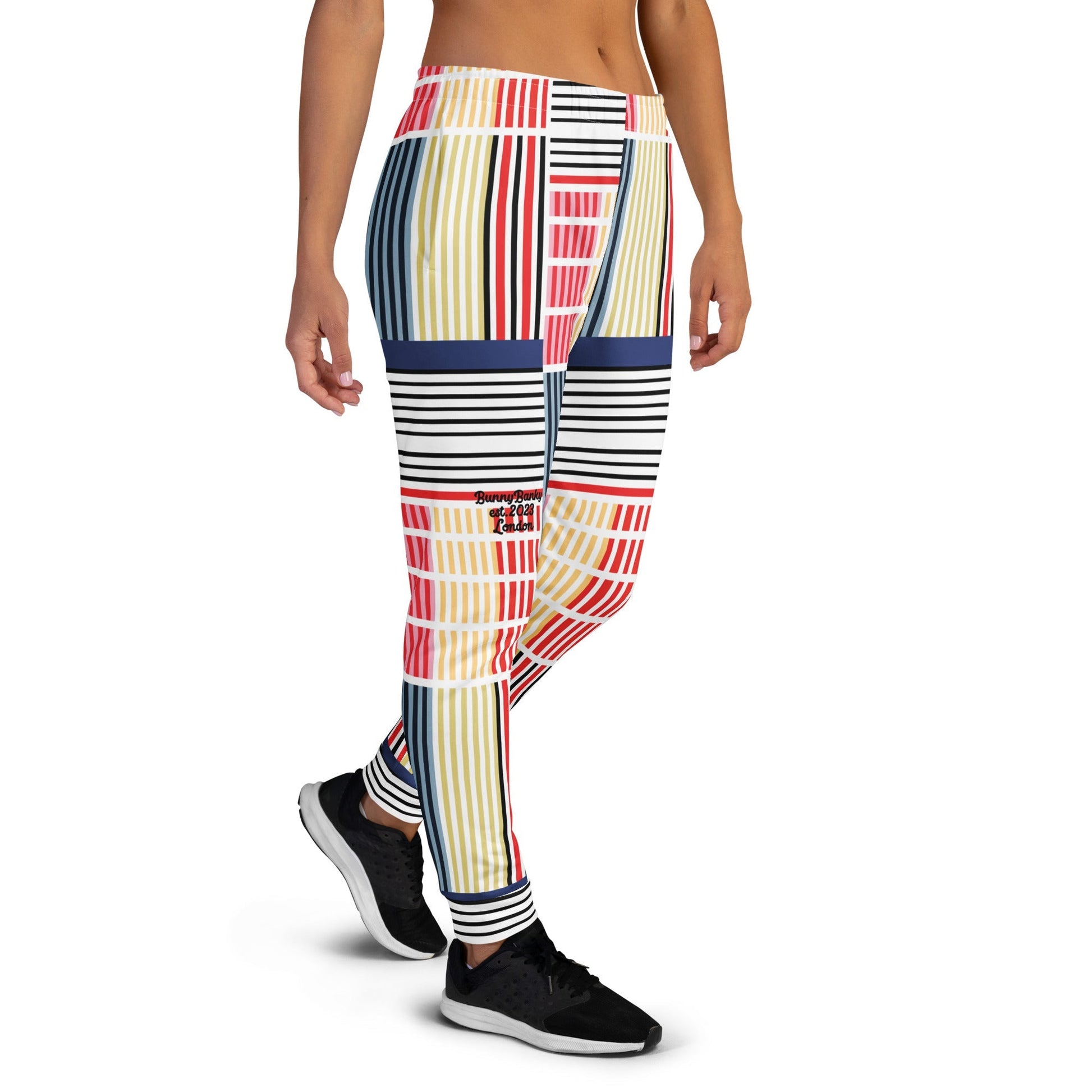 A model wearing The Vienna Slim Joggers, showing the narrow fit, cuffed ankles, and the Art Nouveau graphic print in primary colors.