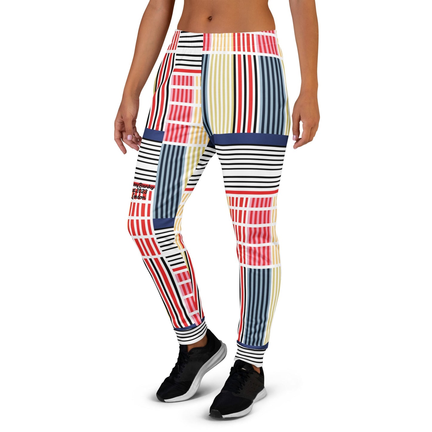 A model wearing The Vienna Slim Joggers, showing the narrow fit, cuffed ankles, and the Art Nouveau graphic print in primary colors.