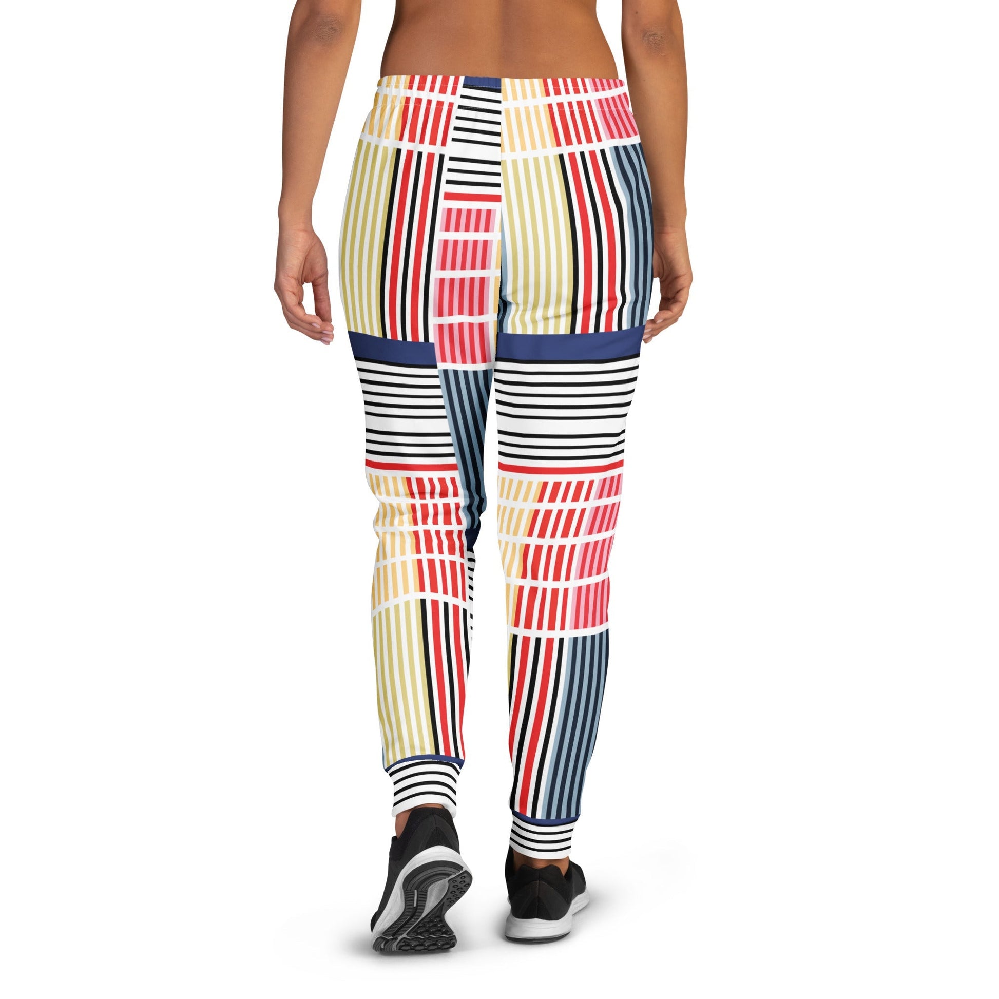A model wearing The Vienna Slim Joggers, showing the narrow fit, cuffed ankles, and the Art Nouveau graphic print in primary colors.