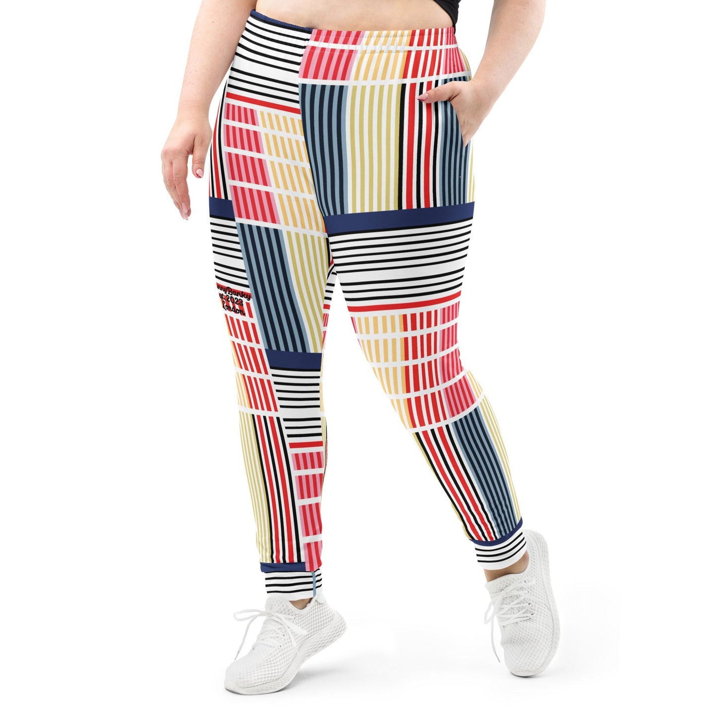 A model wearing The Vienna Slim Joggers, showing the narrow fit, cuffed ankles, and the Art Nouveau graphic print in primary colors.